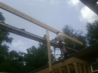 Carpenter setting a ridge beam over a new addition frame — Ice Dam Removal by Roofing Brothers in Lake Forest