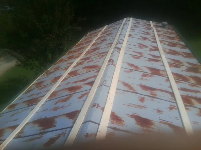 Rusted metal roof panels with new wood purlins before replacement — Storm Damage Roof Repair in Lake Forest by Roofing Brothers