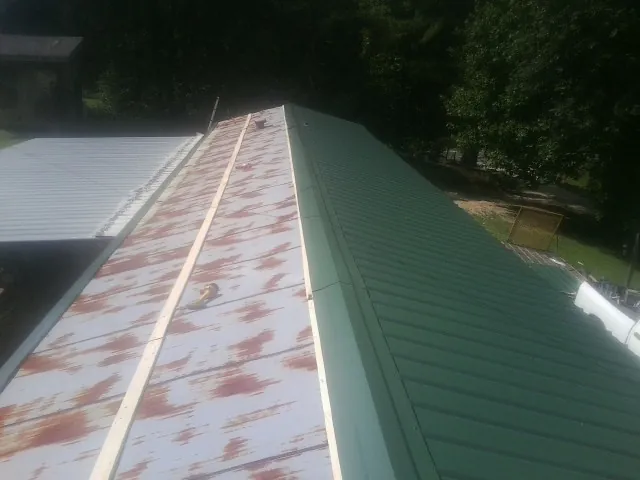 Old rusted panels beside newly installed green metal roofing — Wind Damage Roof Repair by Roofing Brothers in Lake Forest