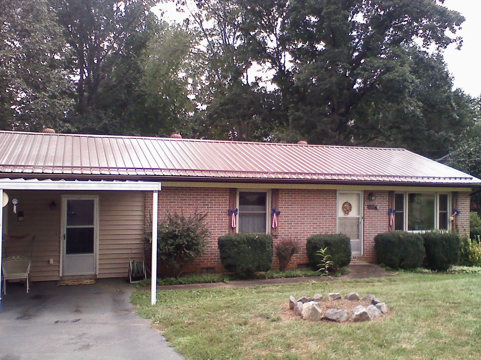 Bronze metal roof and carport on a brick ranch home — Roof Repair work by our crew in Lake Forest